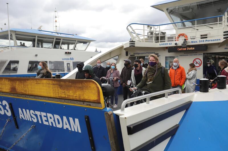 People wearing masks are seen on a ferry following the new social restrictions announced by the Dutch government in Amsterdam. Reuters