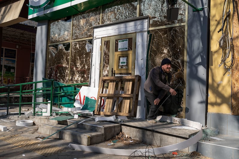 A man leaves a damaged pharmacy after a bombing that killed several civilians, in Mykolaiv. AP