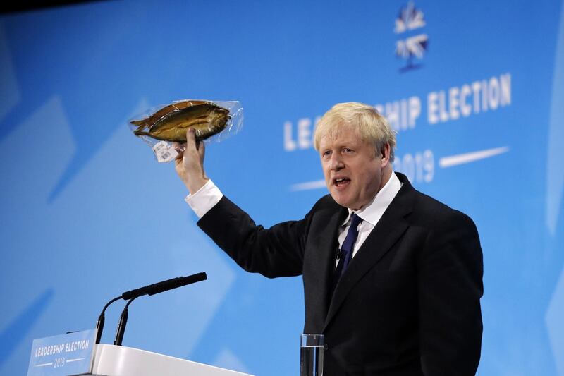 Conservative MP and leadership contender Boris Johnson holds up kipper fish in plastic packaging as he speaks at the final Conservative Party leadership election hustings in London, on July 17, 2019.
  The battle to become Britain's next prime minister enters the home straight on Wednesday with both candidates hardening their positions on Brexit, putting the future government on a collision course with Brussels. / AFP / Tolga AKMEN

