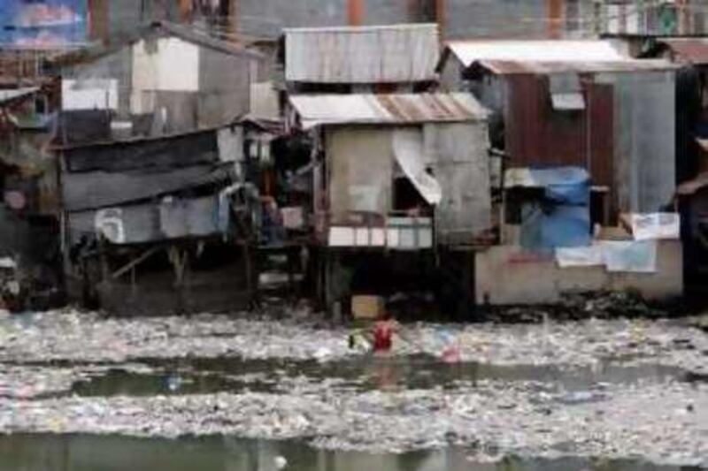 A boy collects recyclables for sale along the polluted Pasig River during Earth Day in Manila April 22, 2009.  REUTERS/John Javellana (PHILIPPINES SOCIETY ENVIRONMENT)