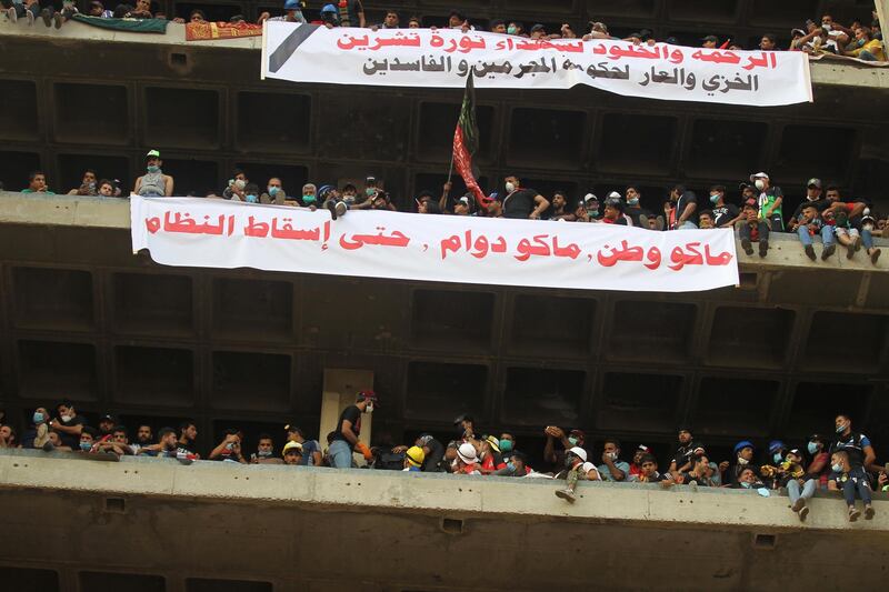 Banners reading "mercy and immortality to the martyrs of the October revolution; no nation, no work, until the downfall of the regime" from the vacant Turkish Restaurant Building overlooking Al Jumhuriya bridge. AFP