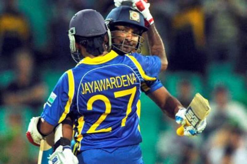 Sri Lankan captain Mahela Jayawardene (L) congratulates his teammate Kumar Sangakkara (R) after he had reached the milestone of 10,000 runs during the one-day international cricket match against Australia in Sydney on February 17, 2012. IMAGE STRICTLY RESTRICTED TO EDITORIAL USE - STRICTLY NO COMMERCIAL USE  AFP PHOTO / Greg WOOD

 *** Local Caption ***  889687-01-08.jpg