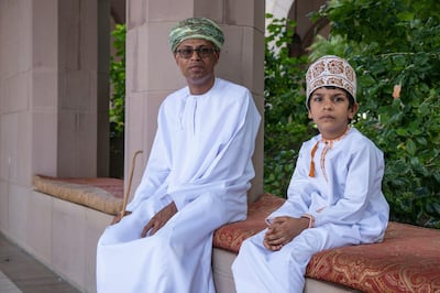 An Omani man and boy wear national dress. Unsplash 