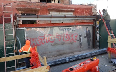 Fine Art Shippers work to remove then transport 'Ghetto 4 Life' by Banksy in New York City. Photo: Fine Art Shippers