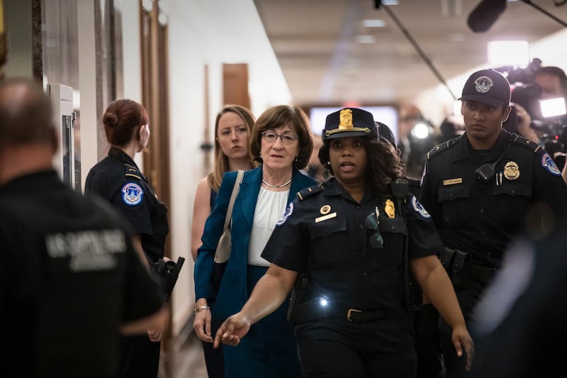 Sen. Susan Collins, R-Maine, is escorted by U.S. Capitol Police past waiting reporters trying to ask about Supreme Court nominee Brett Kavanaugh, on Capitol Hill in Washington, Wednesday, Oct. 3, 2018. Sen. Collins, whose vote on Kavanaugh is uncertain, was leaving the Senate Special Committee on Aging which she chairs. (AP Photo/J. Scott Applewhite)
