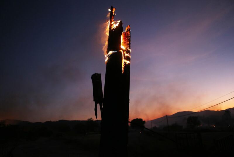 A utility pole burns during the Tick Fire in Canyon Country. AFP