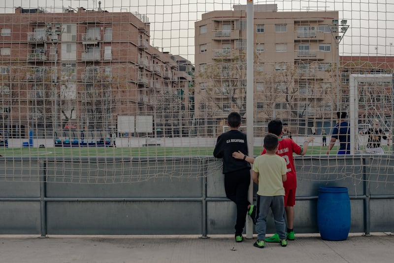 Children watch on as other kids play football at Rocafonda Football Club, the hometown of Barcelona starlet Yamine Lamal. Photo: Hannah Cauhepe for The National