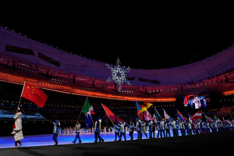 Flag bearers walk into the stadium for the closing ceremony of the 2022 Winter Olympics. AP