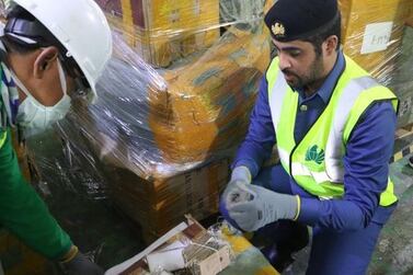 Dubai Customs officers uncover a shipment of fake mobile phones in July 2020. The customs office often recycles counterfeit goods to protect consumers and limit environmental damage. Courtesy: Dubai Customs