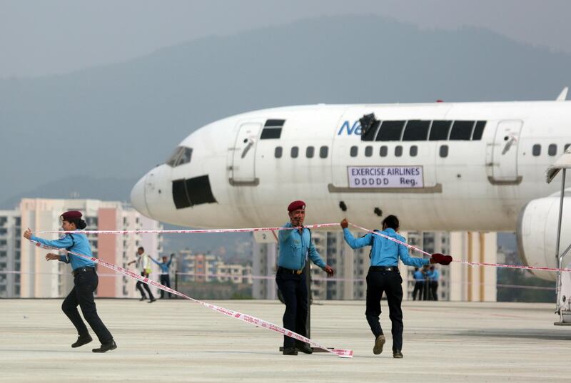 Nepalese policemen secure the area with barricade tape during an emergency drill at Tribhuvan International Airport in Kathmandu, Nepal, Friday, June 28, 2019. The drill was conducted as part of the International Civil Aviation Organization regulations. (AP Photo/Niranjan Shrestha)