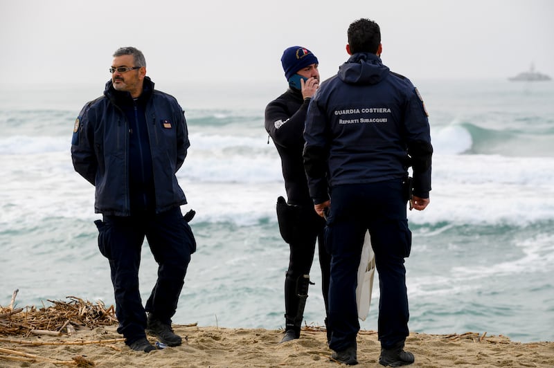 Italian Coastguard officers stand by as rescue crews search for people believed still missing from the migrant shipwreck. AP