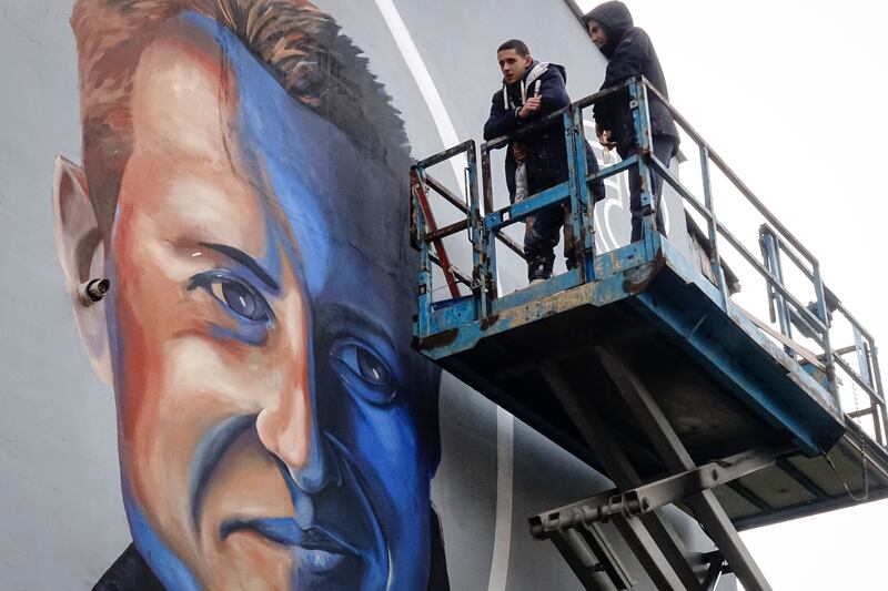Benjamin Cengic next to his mural of Michael Schumacher in Sarajevo, Bosnia. AP