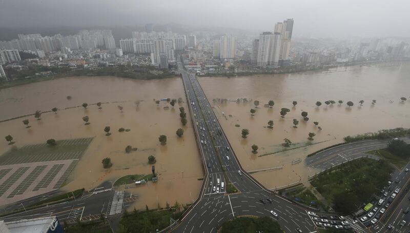 A part of a road and riverside near the Taehwa River are flooded due to heavy rain in Ulsan, South Korea.  AP