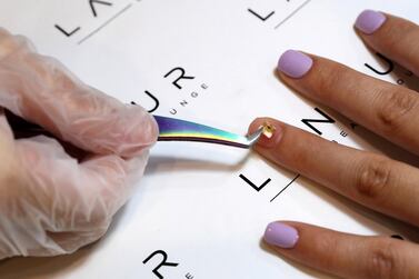 A microchip is placed on a fingernail at the Lanour Beauty Lounge in Dubai.  Pawan Singh / The National