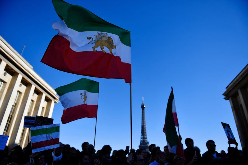 People wave the Shah-era Iranian flag during a protest in Paris. AFP