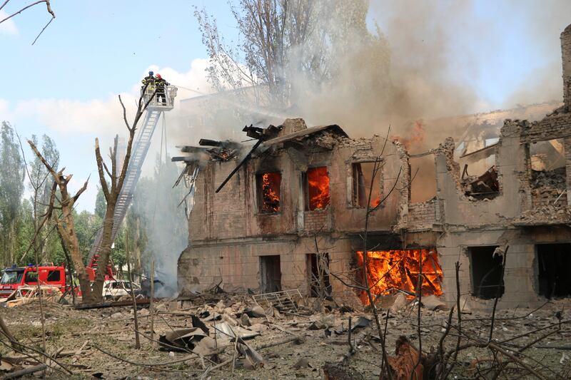 Firefighters hose down a building after the Russian attack in Dnipro, Ukraine. AP