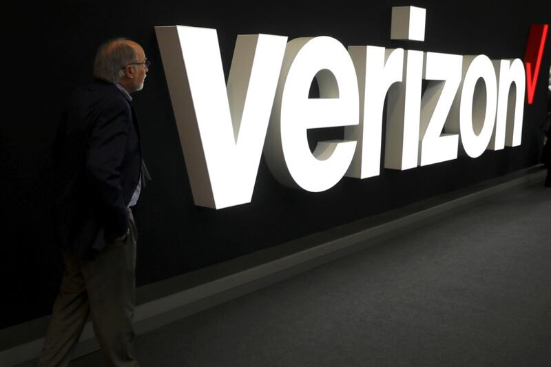 FILE PHOTO: A man stands next to the logo of Verizon at the Mobile World Congress in Barcelona, Spain, February 26, 2019. REUTERS/Sergio Perez/File Photo  GLOBAL BUSINESS WEEK AHEAD
