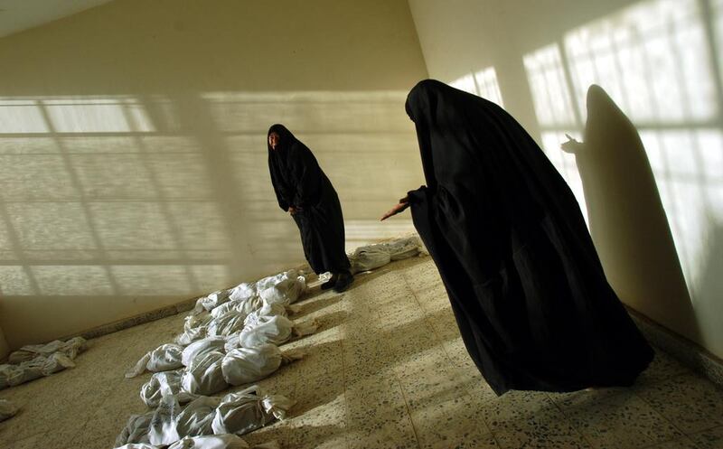 Iraqi women weep as they walk along rows of remains of bodies, some looking for loved ones, discovered  in a mass grave South of Bagdad, and lied out in a building in Iraq, 2003. Since the fall of Saddam Hussain’s regime in Iraq, thousands of bodies have been pulled from mass grave sites around the country, evidence of the brutal, bloody regime of the former dictator. Courtesy Lynsey Addario