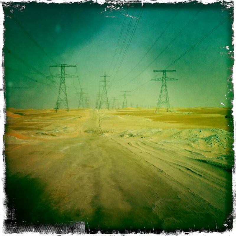 Day trip with friends to the Western Region and the Mazayin Dhafra Camel Festival, 220 kms west of Abu Dhabi on December 20, 2013. We accidentally followed this road under high tension wires.  Picture taken with the Hipstamatic app for the iPhone. Liz Claus / The National