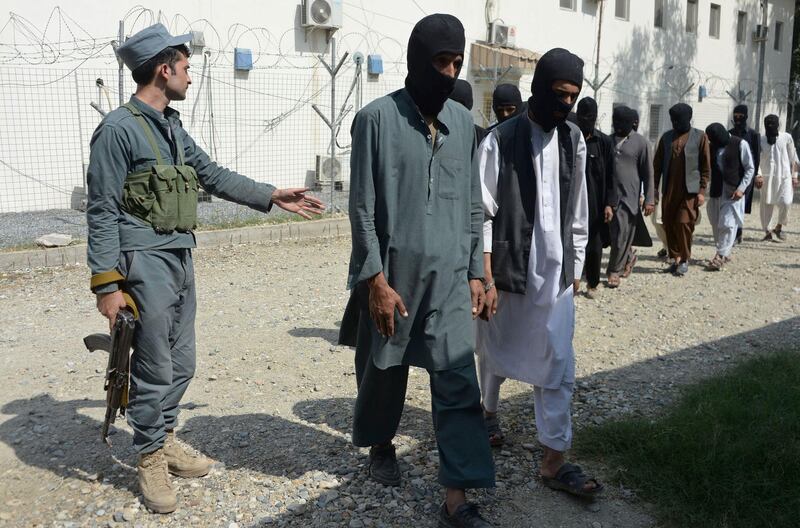 (FILES) This file photo taken on October 3, 2017 shows a member of the Afghan security forces escorting alleged Islamic State fighters and Taliban being presented to the media at the police headquarters in Jalalabad.
French and Algerian fighters, some arriving from Syria, have joined the ranks of the Islamic State group in northern Afghanistan where the militants have established new bases, multiple international and Afghan sources have told AFP. It is the first time that the presence of French IS fighters has been recorded in Afghanistan, and comes as analysts suggested foreigners may be heading for the war-torn country after being driven from Syria and Iraq.
 / AFP PHOTO / NOORULLAH SHIRZADA