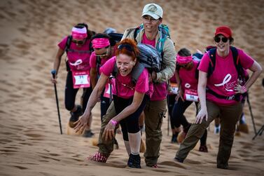 TOPSHOT - Women take part in the desert trek "Rose Trip Maroc", on November 4, 2019 in the erg Chebbi near Merzouga. The Rose Trip Maroc is a female-oriented trek where teams of three must travel through the southern Moroccan Sahara desert with a compass, a map and a topographical reporter. / AFP / JEAN-PHILIPPE KSIAZEK