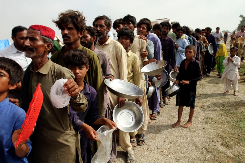 Flood-affected people wait for food distributed by army troops in a flood-hit area of Punjab, Pakistan, on August 27. AP