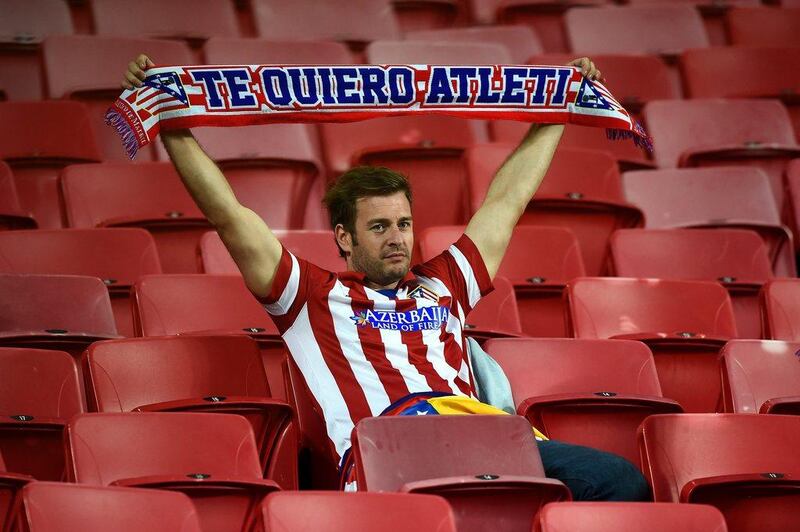 An Atletico Madrid fan holds up his scarf after his club loses the Champions League final to Real Madrid on Saturday, Laurence Griffiths / Getty Images / May 24, 2014