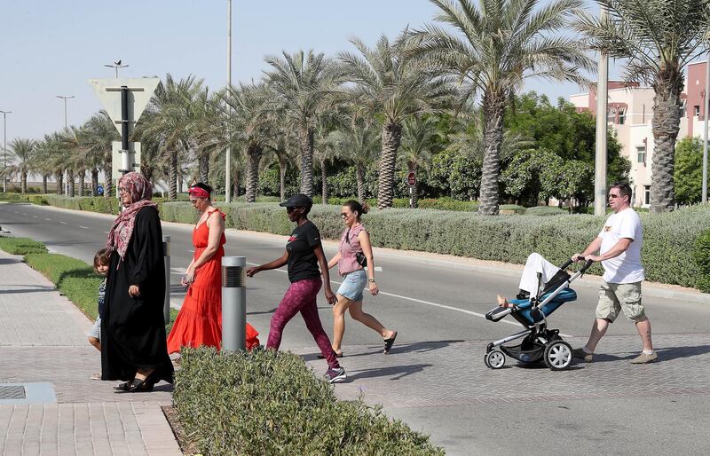 ABU DHABI ,  UNITED ARAB EMIRATES , AUGUST 28 – 2019 :- Jon Edwards ( in white t-shirt ) crossing the pedestrian way with other residents at the Al Ghadeer residential area in Abu Dhabi. These residents are worried about the dangerous driving by the car drivers around the area. ( Pawan Singh / The National ) For News. Story by Patrick