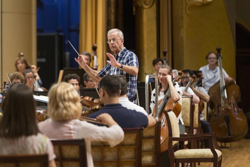 Sir Richard Armstrong leads the Western Australia Symphony Orchestra in rehearsal for Abu Dhabi Classics’ season opener at Emirates Palace on Thursday night. Antonie Robertson / The National