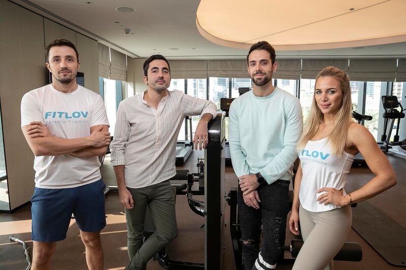 Fitlov co-founders Alberto Pardo, second right, and Alvaro Zapata, second left, with two of the company's trainers. Antonie Robertson / The National