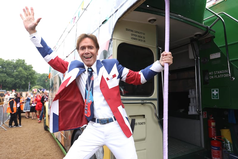 Sir Cliff Richard climbs onboard the 1950s bus at Horse Guards Parade for the pageant. PA