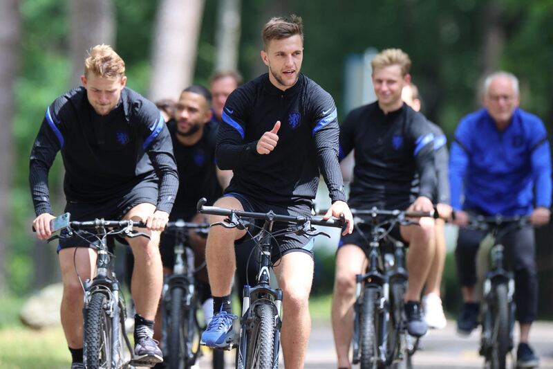 Joel Veltman (C) and teammates ride bikees after a training session in Zeist ahead of the Euro 2020 Group C match against North Macedonia. AFP