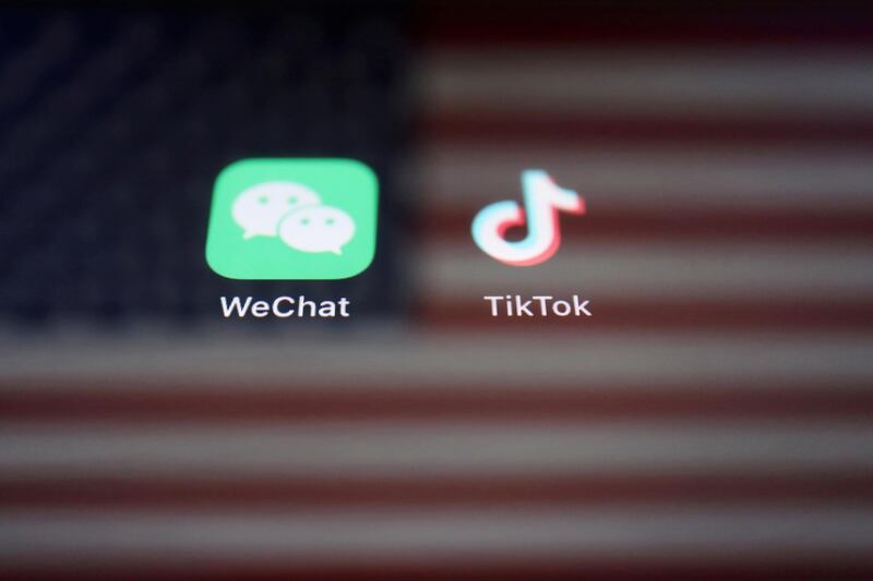 FILE PHOTO: A reflection of the U.S. flag is seen on the signs of the WeChat and TikTok apps in this illustration picture taken September 19, 2020. REUTERS/Florence Lo/Illustration/File Photo
