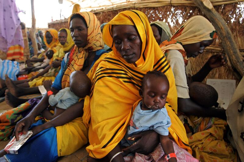 Malnourished children are fed at the Medecins Sans Frontiers (MSF) (Doctors without Borders) the French medical charity, nutrition centre 21 June 2004 in the Mornay camp, in western Darfur, Sudan. More than 80,000 displaced people reached this town to try to escape ethnic violence in the Darfur region. After surviving massacres carried out by pro-government militias on their villages, these refugees are now virtual prisoners in the camp as the same militias now control the camp's periphery conducting violent attacks and rapes on villagers who go out looking for food and essential items according to MSF. AFP PHOTO/MARCO LONGARI (Photo by MARCO LONGARI / AFP)