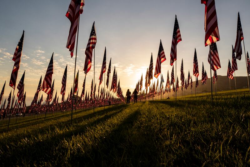 People walk among the flags of the commemorative installation 'Waves of Flags' on the eve of the 20th anniversary of 9/11 at the Pepperdine University in Malibu, California. EPA