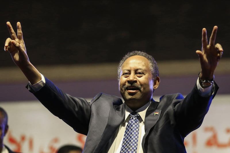 (FILES) This file photo taken on December 25, 2019 shows Sudanese Prime Minister Abdullah Hamdock flashing the victory sign during a ceremony marking the first anniversary of the uprising that toppled Omar al-Bashir. Sudan's Prime Minister Abdallah Hamdok survived unharmed an assassination attempt using explosives in the capital Khartoum on March 9, 2020, according to his top aide. A cabinet official also confirmed to AFP that Hamdok had escaped an attack.  / AFP / ASHRAF SHAZLY
