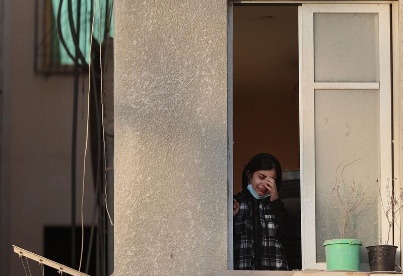 A Palestinian girl cries as she looks out from her home's window at destroyed neighbouring buildings in a residential area of Gaza City, following Israeli air strikes. AFP