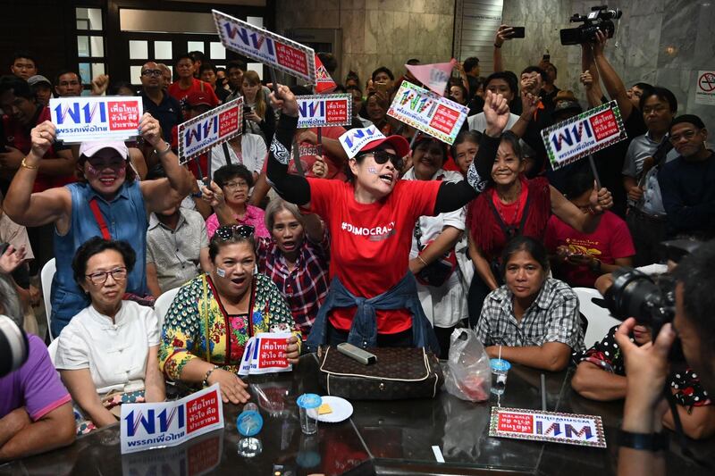 TOPSHOT - Supporters of the Pheu Thai party react at the party's headquarters in Bangkok on March 24, 2019 after polls closed in Thailand's general election. / AFP / Ye Aung THU

