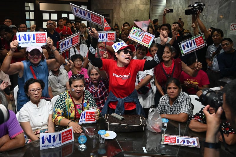 TOPSHOT - Supporters of the Pheu Thai party react at the party's headquarters in Bangkok on March 24, 2019 after polls closed in Thailand's general election. / AFP / Ye Aung THU
