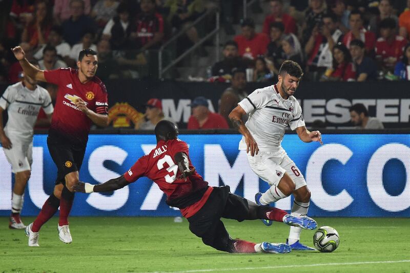 AC Milan's Patrick Cutrone fights for the ball with Manchester United's Eric Bailly. AFP