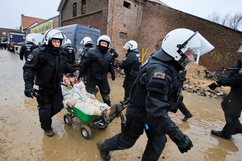 Police officers take away one of the activists. Reuters