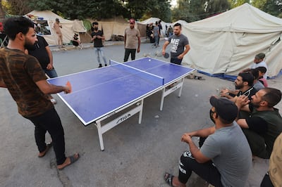 Supporters of the Hashed Al Shaabi alliance, or the Popular Mobilisation Forces, play ping-pong during a sit-in outside the capital Baghdad's Green Zone area, on October 26. AFP