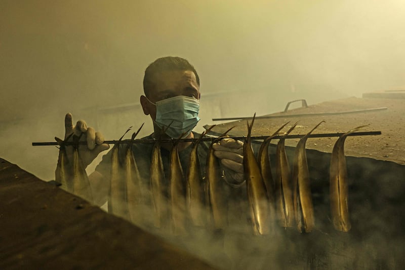 A Palestinian worker prepares smoked fish at a factory in Rafah. AFP