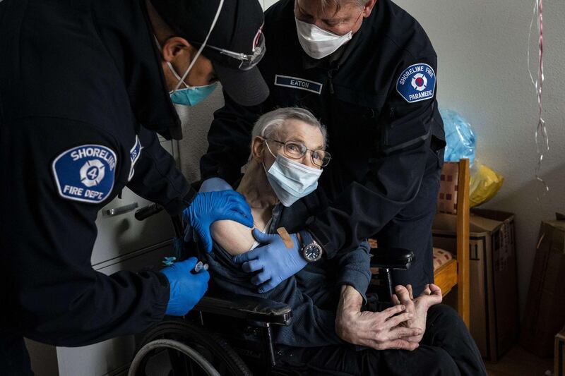 Members of a mobile Covid-19 vaccination team with the Shoreline Fire Department vaccinate a resident at an adult family home in Shoreline, Washington. AFP