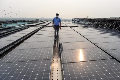 In this photograph taken on July 17, 2020, an employee walks among solar panels installed on the building of Indira Paryavaran Bhawan or the Indian Environment Ministry in New Delhi. / AFP / Money SHARMA
