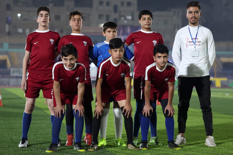 Children wearing Qatar jerseys take a group photo before competing