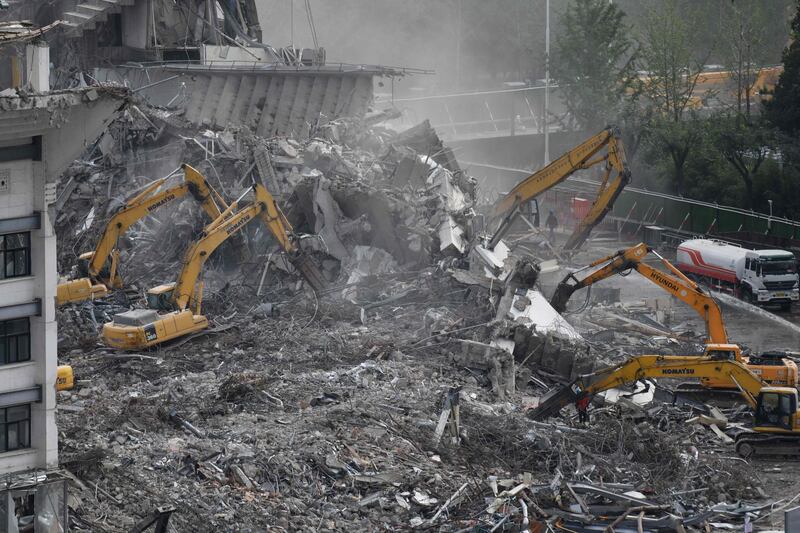 Excavators clear rubble during demolition of the Workers' Stadium. AFP