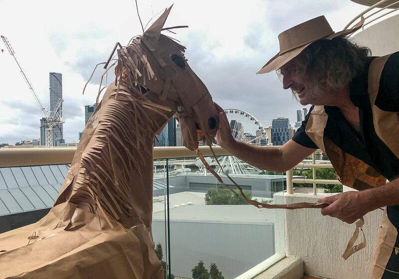 David Marriott poses with his paper horse in his hotel room in Brisbane, Australia, April 3, 2021. While in quarantine inside his Brisbane hotel room, art director Russell Brown was bored and started making a cowboy outfit from the paper bags his meals were being delivered in. His project expanded to include a horse and a clingfilm villain that he has daily adventures with, in images that have gained a huge online following. (David Marriott via AP)