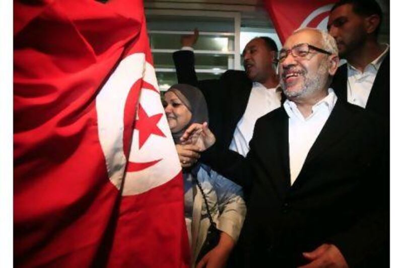 Rached Ghannouchi (R), leader of the Islamist Ennahda movement in Tunisia, smiles as he meets his supporters after the announcement of the country's election results Thursday. The party won 90 seats in the 217-seat assembly.