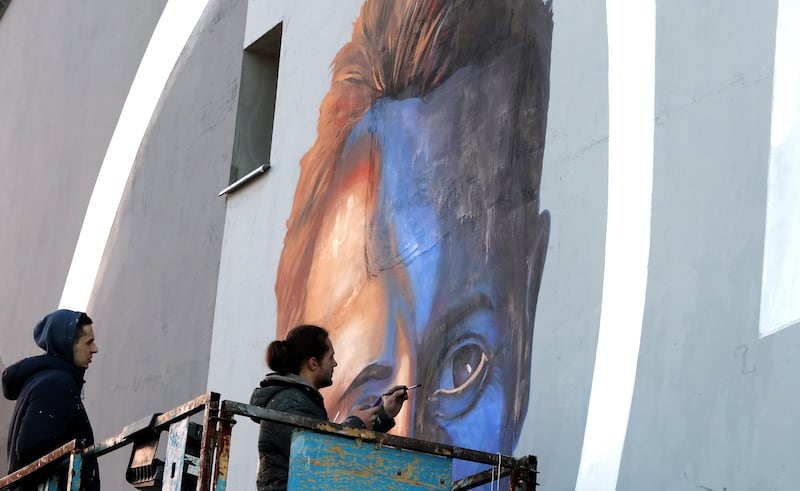 Bosnian artists work on a mural of Michael Schumacher. The artwork is painted on a side of a building that was partially rebuilt by donations raised by Schumacher after the war in Bosnia. EPA
